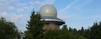 Das Radargerät bei Erndtebrück: Das runde Radom, die Schutzhülle des Radars, ragt über den Baumwipfeln in den Himmel.