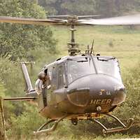 Ein Bundeswehrhubschrauber beim Landeanflug im Gelände.