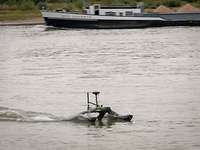 Eine kleine Drohne fährt auf dem Wasser über den Rhein.