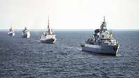 Vier Kriegsschiffe verschiedener Nationen fahren hintereinander in der Ostsee