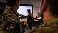 Mehrere Soldaten interagieren in einem Raum.