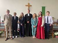 Konfirmation in Brunssum Ein Pfarrer in der Mitte mit sechs Konfirmanden