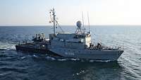 Ein kleines Schiff der Marine fährt auf einem Gewässer