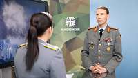 Generalmajor Dr. Christian Freuding bei „Nachgefragt“ Eine Soldatin und ein Soldat stehen sich gegenüber und sprechen miteinander.