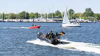 Ein Schlauchboot mit Soldaten an Bord fährt in einem Hafengebiet bei der Übung National Guardian 2024.