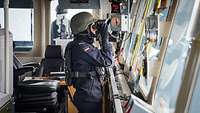 Ein Soldat schaut auf der Brücke eines Schiffs durch ein Fernglas bei der Übung Northern Coasts 2024