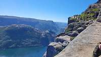 Ein felsiger Aufstiegsweg mit Blick auf einen Fjord