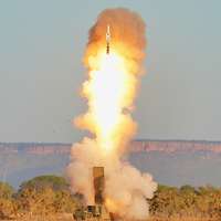 Ein Fahrzeug mit einer Abschussrampe schießt eine Rakete ab. Eine große Feuerwolke entsteht.
