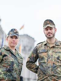 Eine Soldatin und ein Soldat posieren vor dem Reichstag