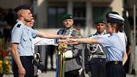 Soldaten halten die linke Hand über eine Deutschlandflagge