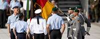 Soldaten stehen neben der Deutschlandfahne in Grundstellung