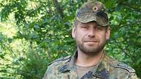 Soldat in Kampfanzug blickt in die Kamera.