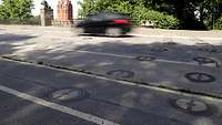 Reihen runder Abdeckungen in einer asphaltierten Straße