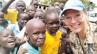 Oberstleutnant Nancy W. umringt von Kindern der Kings Wisdom Nursery and Primary School in Gumbo