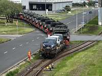 Mehrere Fahrzeuge sind auf Eisenbahnwagen verladen
