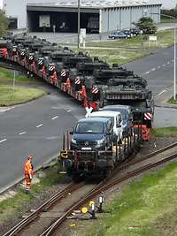 Mehrere Fahrzeuge sind auf Eisenbahnwagen verladen