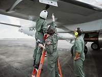 Seefernaufklärer P-8A Poseidon – Ausbildung in den USA Ein Soldat hantiert auf einer Leiter an einem Flugzeugflügel. Neben ihm stehen zwei Soldaten.