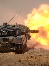 Ein Panzer schießt, an der Kanonenmündung entsteht ein gewaltiger Feuerball.