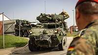 Gefechtsfahrzeuge des US-Militärs rollen durch Tore einer deutschen Kaserne.