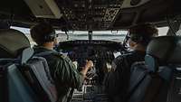 P-8A Poseidon Ausbildung in den USA Ein deutscher und ein US-amerikanischer Soldaten sitzen im Cockpit eines Flugzeugs