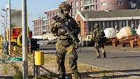 Deutscher Soldat läuft in voller Ausrüstung mit Gewehr und Helm Patrouille.