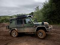 Ein Geländewagen Wolf 2 fährt durch ein unebenes und schlammiges Gelände.