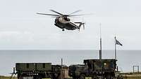 Eine CH-53 fliegt über den Feuerleitstand eines Patriot-Systems.