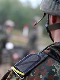 Ein Soldat mit silberner Kordel und zitronengelber Litze an der Schulterklappe des Feldanzugs