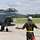 Ein Kampfjet vom Typ Eurofighter fährt am Boden und ein Soldat weißt ihn ein.