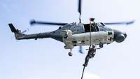 Ein Soldat seilt sich von einem Hubschrauber ab