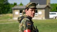 Ein Soldat mit roter Armbinde blickt in die Kamera.