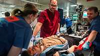 An injured man lies on a stretcher