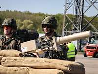 Two soldiers with a drone defense device at a checkpoint