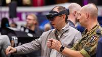 Ein Mann mit VR-Brille steht neben einem Soldaten.