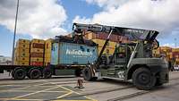 Ein Containerstapler beim Anheben eines Containers von einer LKW-Ladefläche