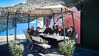  Mehrere Soldatinnen und Soldaten sitzen unter einem Pavillon in einer Kaffeerunde