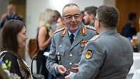 Carsten Breuer unterhält sich mit einem Soldaten und lächelt dabei.