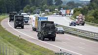 Militärfahrzeuge fahren in einer Kolonne auf der Autobahn