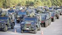 Mehrere Militärfahrzeuge parken neben und hintereinander