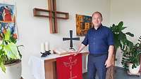Ein Mensch steht an einem Altar und blickt in die Kamera