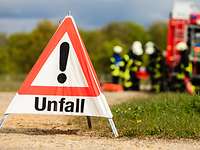 Unfallschild Ein aufgestelltes Unfallschild auf einer Straße, im Hintergrund Feuerwehr