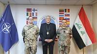 Zwei Soldaten und ein Bischof stehen zwischen zwei Flaggen