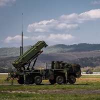 Von der Seite ist ein Flugabwehrraketensystem Patriot auf offenem Gelände zu erkennen.