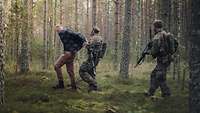 Soldaten führen im Wald einen festgesetzten gegnerischen Soldaten ab.