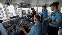Soldatinnen und Soldaten in blauer Uniform arbeiten auf einem Schiff