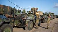 Soldaten in Flecktarn Uniform verladen Muniton auf ihren militärischen Fahrzeugen.