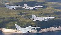 Vier Kampfjets fliegen in Formation an der Kreideküste der Insel Rügen entlang