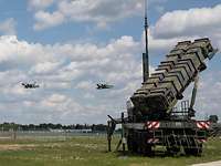 Zwei Kampfflugzeuge fliegen über Patriotsysteme