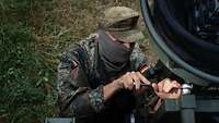 Soldat schraubt eine Mutter ab.