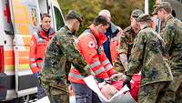 Soldaten und zivile Rettungskräfte arbeiten Hand in Hand